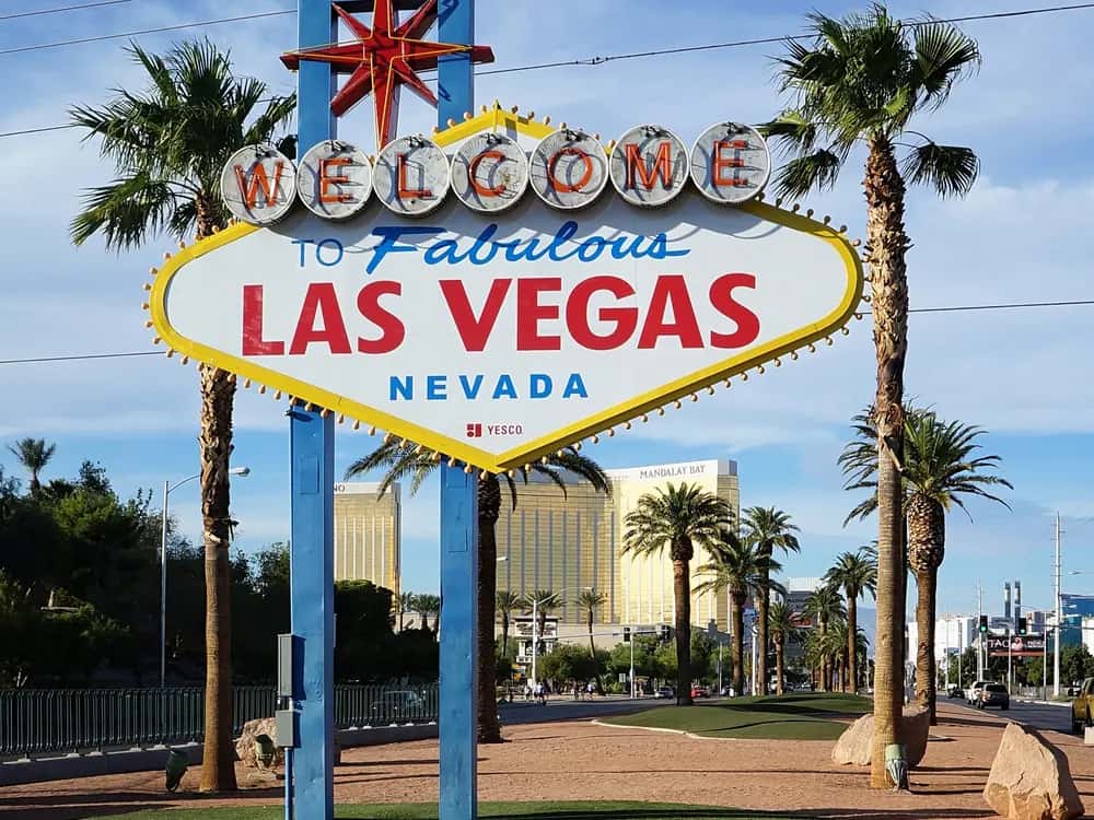 The Welcome to Fabulous Las Vegas sign between palm trees under a blue sky.